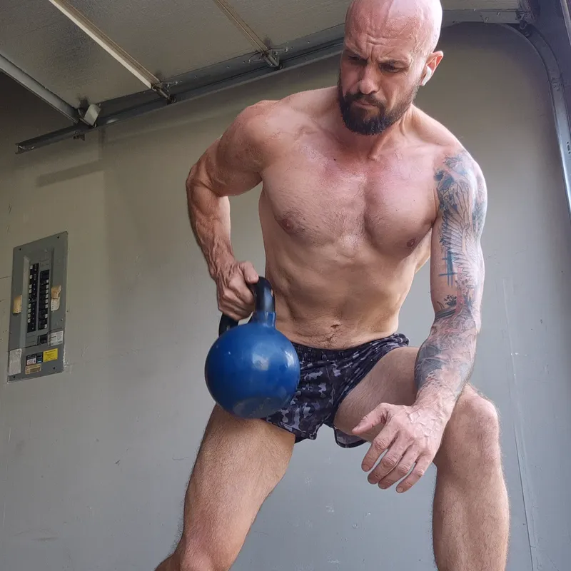 Single arm supported kettlebell row with the free hand braced on the knee
