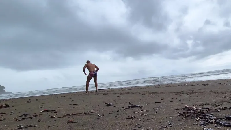 Josh landing a single-leg hop on wet packed sand at Playa Ventanas with the surf behind him